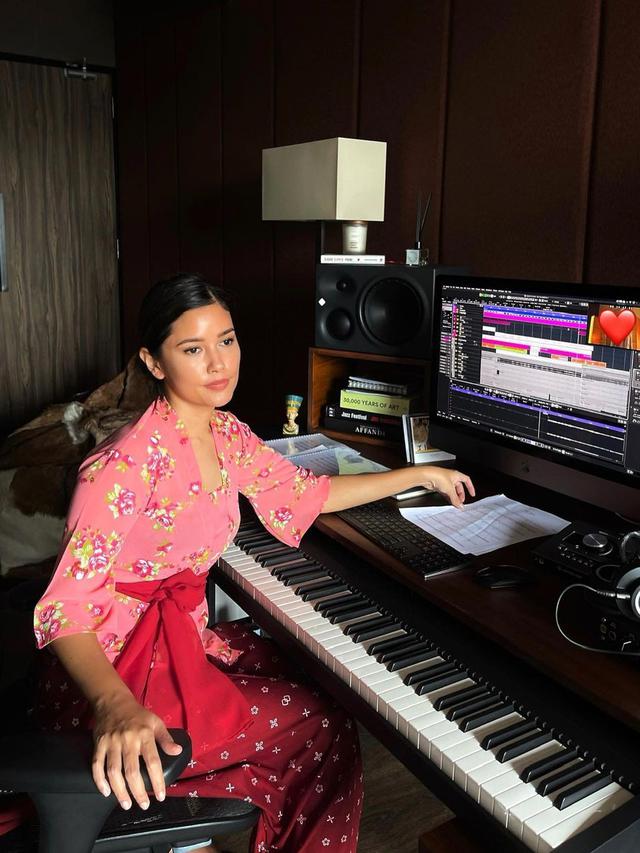 Titi Radjo Padmaja kenakan kebaya lengan 3/4 warna pink bermotif bunga dipadukan bawahan rok lilit jumputan dan sabuk prada warna merah