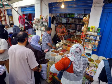 Warga membeli produk makanan untuk persiapan menyambut datangnya bulan Ramadan di Ibu Kota Tripoli, Libya, 1 Mei 2019. Kendati tertekan lantaran dibayang-bayangi oleh pertempuran antara pasukan pemerintah dengan pemberontak, warga Tripoli tetap antusias menyambut Ramadan. (MAHMUD TURKIA/AFP)