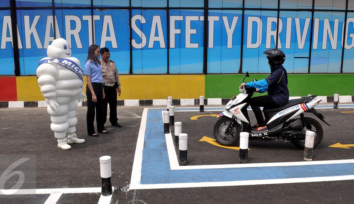 Kasubdit Dikyasa Polda Metro Jaya AKBP Ipung Purnama bersama Public Affairs PT Michelin Indonesia Nora Guitet, saat melakukan meninjau salah satu siswa yang melakukan ujian praktek membuat sim di Samsat, Jakarta, (1/11/2015). (Liputan6.com/Johan Tallo)