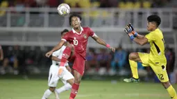 Pemain Timnas Indonesia U-20, Ronaldo Kwateh berusaha melewati hadangan penjaga gawang Timnas Timor Leste U-20 dalam laga pertama Grup F Kualifikasi Piala Asia U-20 2023 di Stadion Gelora Bung Tomo, Surabaya (14/9/2022). (Bola.com/Ikhwan Yanuar)
