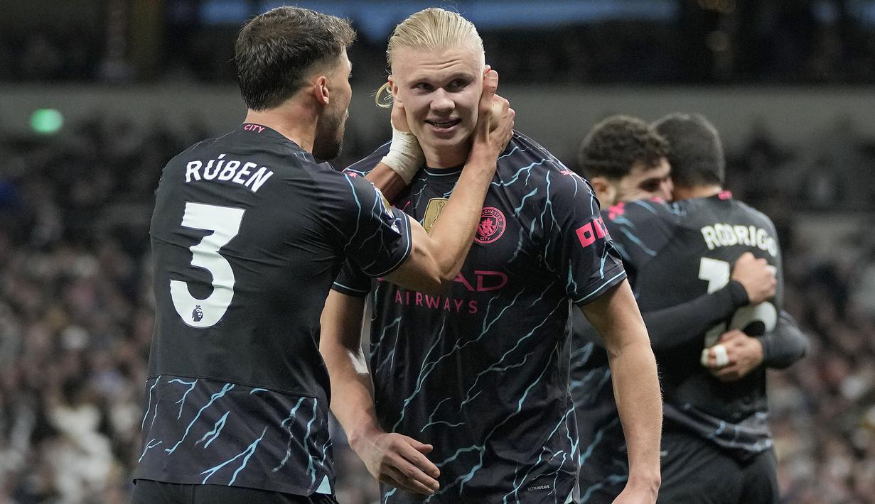Manchester City kian dekat dengan gelar juara Liga Inggris 2023/2024 usai kemenangan 2-0 di kandang Tottenham Hotspur pada laga tunda pekan ke-34, Rabu (15/5/2024) dini hari WIB. Dua gol kemenangan The Citizens dihasilkan lewat brace Erling Haaland pada menit ke-51 dan injury time babak kedua. Dengan hasil ini, Man City kembali merebut posisi puncak dari Arsenal dengan keunggulan dua poin, 88 berbanding 86. Dengan sama-sama menyisakan satu laga lagi di pekan pamungkas, pasukan Pep Guardiola semakin dekat dengan gelar juara Liga Inggris musim ini sekaligus mencetak rekor menjadi tim pertama yang mampu juara Liga Inggris 4 musim beruntun. (AP Photo/Kin Cheung)
