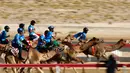 Para joki bersaing saat mengikuti balapan unta selama festival warisan Sheikh Sultan Bin Zayed al-Nahyan di Abu Dhabi, Uni Emirat Arab (10/2). (AFP/Karim Sahib)
