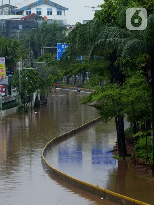 Suasana Jalan Raya Daan Mogot yang terendam banjir di Jakarta, Rabu (1/1/2020). Hujan yang turun saat malam pergantian tahun baru 2019-2020 menyebabkan sejumlah titik jalan terputus di kawasan Grogol terendam banjir. (merdeka.com/Imam Buhori)