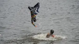 Pria dan anak muda Pakistan mendinginkan diri ke perairan Laut Arab saat musim panas di Karachi pada 5 Juli 2020. Mereka menghabiskan hari yang cerah dengan berenang di tengah pandemi virus corona. (Photo by Rizwan TABASSUM / AFP)