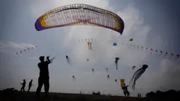 Seorang pria menerbangkan layang-layangnya dalam Varvara Kite Fest di Desa Varvara, pesisir Laut Hitam, Bulgaria, Jumat (27/8/2021). Penyelenggara Varvara Kite Fest Andrey Kulev mengatakan bahwa menerbangkan layang-layang seperti melepaskan semua masalah Anda di langit. (AP Photo/Valentina Petrova)