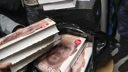 Buku baru Pangeran Harry berjudul "Spare" dipegang oleh anggota staf toko buku saat pembukaan tengah malam di London, Selasa (10/1/2023). Memoar baru Harry yang memamerkan jiwa, "Spare," telah menghasilkan berita utama yang membara bahkan sebelum dirilis. (AP/Alberto Pezzali)