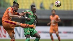 Bek Borneo FC, Yamashita Kunihiro, membuang bola dari kejaran striker Bhayangkara FC, Guy Junior, pada laga Liga 1 Indonesia di Stadion Patriot, Bekasi, Rabu (20/9/2017). Bhayangkara menang 2-1 atas Borneo. (Bola.com/Vitalis Yogi Trisna)