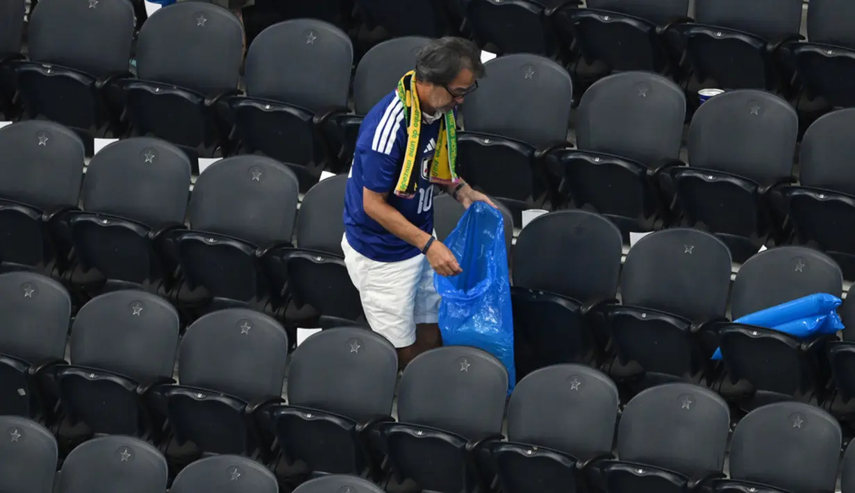 Alih-alih langsung euforia atau terburu-buru pulang, ratusan pendukung Samurai Blue secara tertib tetap tinggal di area tribun untuk memunguti gelas plastik, wadah makanan, dan sisa sampah penonton lain. (AP Photo/Jessica Tobias)