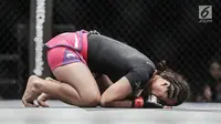 Petarung putri Indonesia, Priscilla Hertati Lumban Gaol sujud syukur usai mengalahkan Petarung putri Malaysia, Audreylaura Boniface saat berlaga pada partai pertama One Championship di Jakarta, Sabtu (20/1). (Liputan6.com/Faizal Fanani)