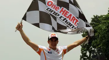 Juara Dunia MotoGP 2013 dan 2014, Marc Marquez membentangkan bendera start di Sirkuit Sentul, Bogor, (21/10/2014). (Liputan6.com/Helmi Fithriansyah)