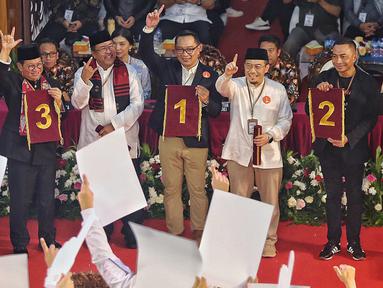 Para kandidat calon gubernur dan calon wakil gubernur DKI Jakarta menunjukkan hasil undian no urut pasangan calon pada Pemilihan Gubernur DKI Jakarta 2024 di Kantor Komisi Pemilihan Umum Daerah (KPUD) Jakarta, di Jalan Salemba Raya, Senen, Jakarta Pusat, Senin (23/9/2024). (Liputan6.com/Angga Yuniar)