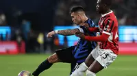 Penyerang Inter Milan asal Argentina Lautaro Martinez mencoba melepaskan tembakan saat ia dijaga oleh bek AC Milan asal Inggris Fikayo Tomori selama pertandingan final Piala Super Italia antara Inter Milan dan AC Milan di Taman Al-Awwal di Riyadh pada 6 Januari 2025.FADEL SENNA / AFP