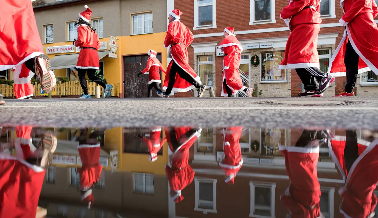 Peserta berkostum Santa Claus ambil bagian dalam kegiatan amal Santa Claus Run di Michendorf, Jerman timur, Minggu (10/12). Kegiatan yang menjadi tradisi umat Kristiani ini diikuti mulai dari orang tua, hingga anak-anak. (Ralf Hirschberger / dpa / AFP)