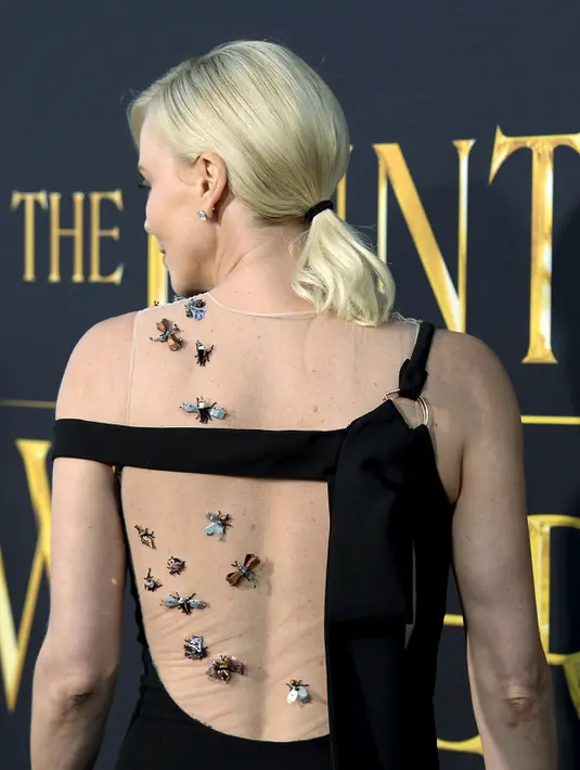 Artis  Charlize Theron saat hadir selama pemutaran perdana film " The Huntsman : Winter War " di Los Angeles , California , (11/4).Uniknya Charlize Theron mengenakan gaun hitam dengan hiasan serangga. (REUTERS / Kevork Djansezian) 