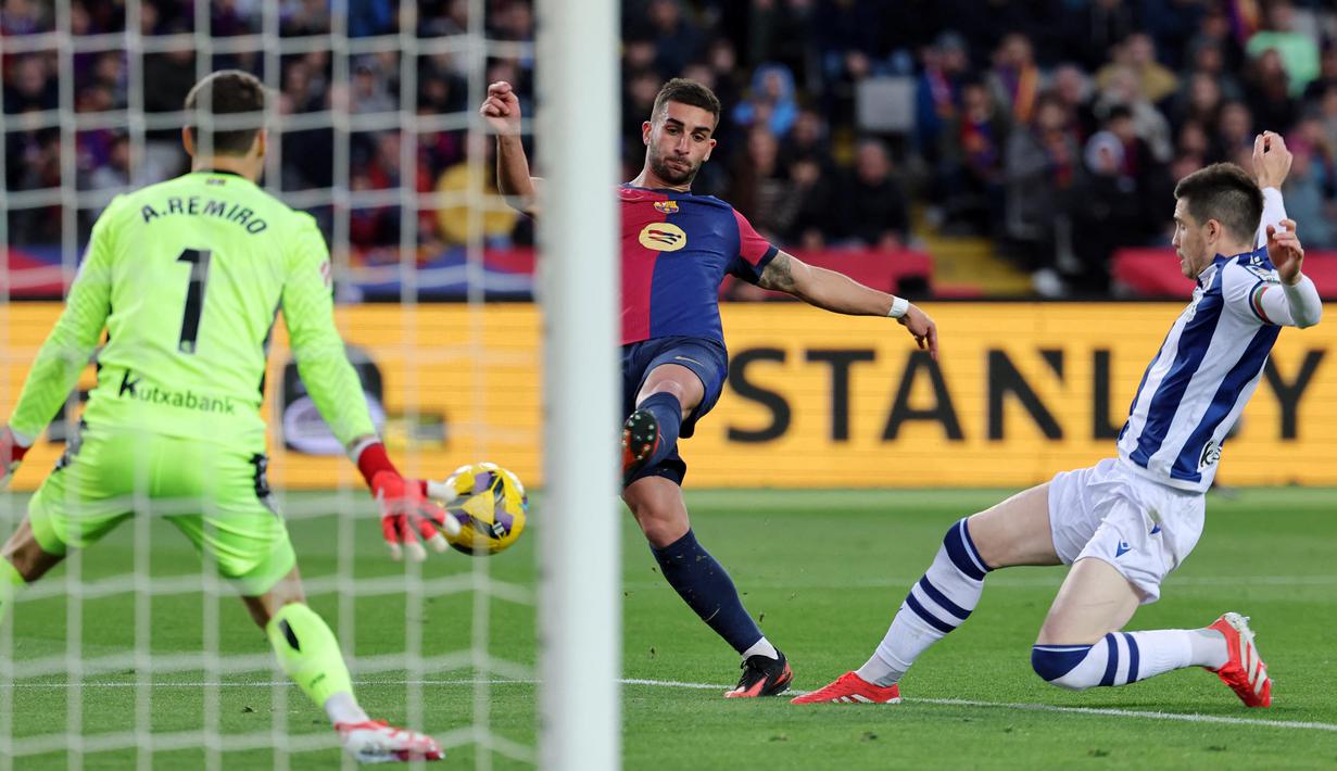Penyerang Barcelona, Ferran Torres (tengah) melakukan tendangan ke arah gawang Real Sociedad pada laga pekan ke-26 Liga Spanyol 2024/2025 di Estadi Olimpic Lluis Companys, Minggu 2 Maret 2025 malam WIB. (LLUIS GENE/AFP)