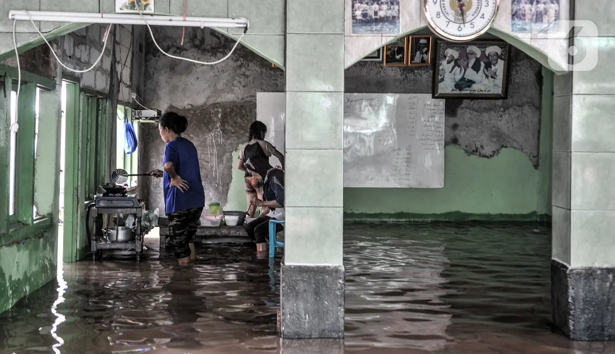 Warga memasak saat banjir merendam permukiman di Kebon Pala, Jakarta, Senin (8/2/2021). Banjir di Kebon Pala terus meninggi pada dini hari tadi hingga mencapai ketinggian 2,5 meter.  (merdeka.com/Iqbal S. Nugroho)