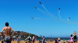 Tim aerobatik Patrulla Aspa bermanuver menggunakan helikopter saat menghebohkan pengunjung pantai di atas Pantai San Lorenzo di Gijon, Spanyol, Minggu (24/7). (REUTERS/Eloy Alonso)