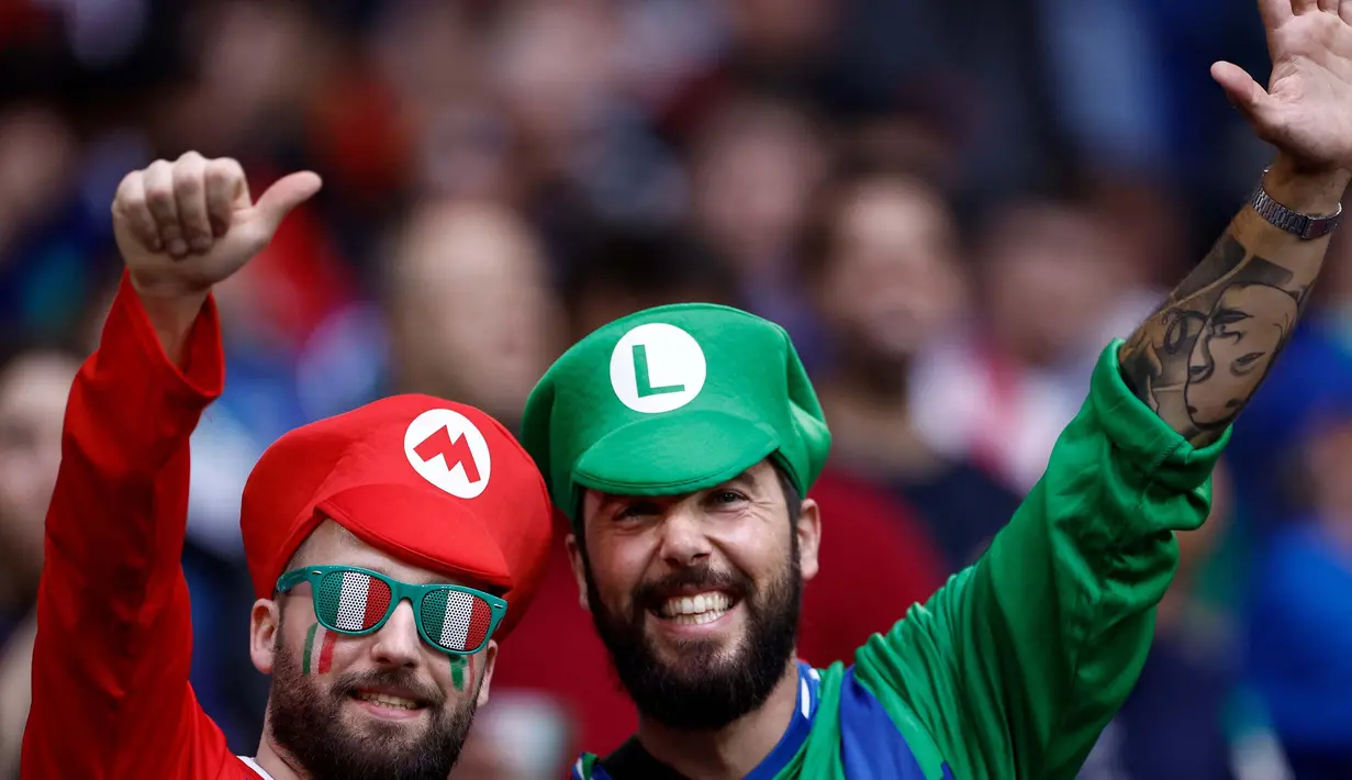 Pendukung Italia yang berpakaian seperti Mario dan Luigi berpose untuk berfoto sebelum dimulainya pertandingan sepak bola Euro 2024 Grup B antara Spanyol dan Italia di Arena AufSchalke, Gelsenkirchen pada 20 Juni 2024. (KENZO TRIBOUILLARD/AFP)