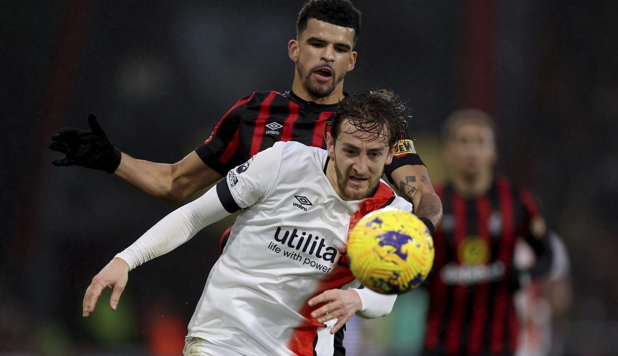 <p>Pemain Luton Town, Tom Lockyear (depan) sebelum dirinya mengalami pingsan secara tiba-tiba di tengah lapangan dalam pertandingan Liga Inggris 2023/2024 antara Bournemouth melawan Luton Town yang berlangsung di Vitality Stadium, Sabtu (16/12/2023). (AP/PA/Steven Paston)</p>