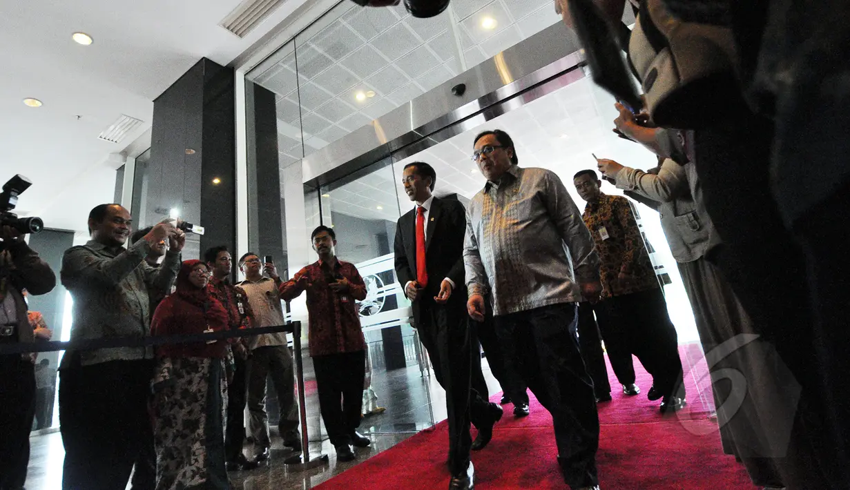 Presiden Joko Widodo didampingi Menkeu Bambang Brodjonegoro (kanan) tiba di kantor Pusat Ditjen Pajak Jakarta, Kamis (19/3). Presiden melaporkan surat pemberitahuan (SPT) pajak tahun 2014 dengan menggunakan sistem e-filling. (Liputan6.com/Faizal Fanani)