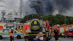 Kendaraan darurat pemadam kebakaran, layanan penyelamatan dan polisi terlihat tidak jauh dari akses jalan ke Chempark di mana asap membubung di Leverkusen, Jerman (21/7/2021). Kepolisian masih menyelidiki kasus ledakan dan belum diketahui penyebab terjadinya ledakan itu. (AP Photo/Oliver Berg)