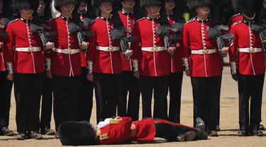 Seorang petugas Pengawal Welsh pingsan dalam cuaca panas selama parade militer yang dikenal sebagai Colonel's Review, latihan terakhir persiapan parade Trooping the Color tahunan, di Horse Guards Parade di London, Sabtu, 10 Juni 2023. (AP Photo/Alberto Pezzali)