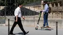 Seorang pria menggunakan skuter listrik saat beraktivitas di Paris, Prancis (9/7). Skuter listrik ini dibuat oleh perusahaan AS Lime yang merupakan penyewaan transportasi sepeda dan skuter di berbagai kota. (AFP Photo/Francois Guillot)