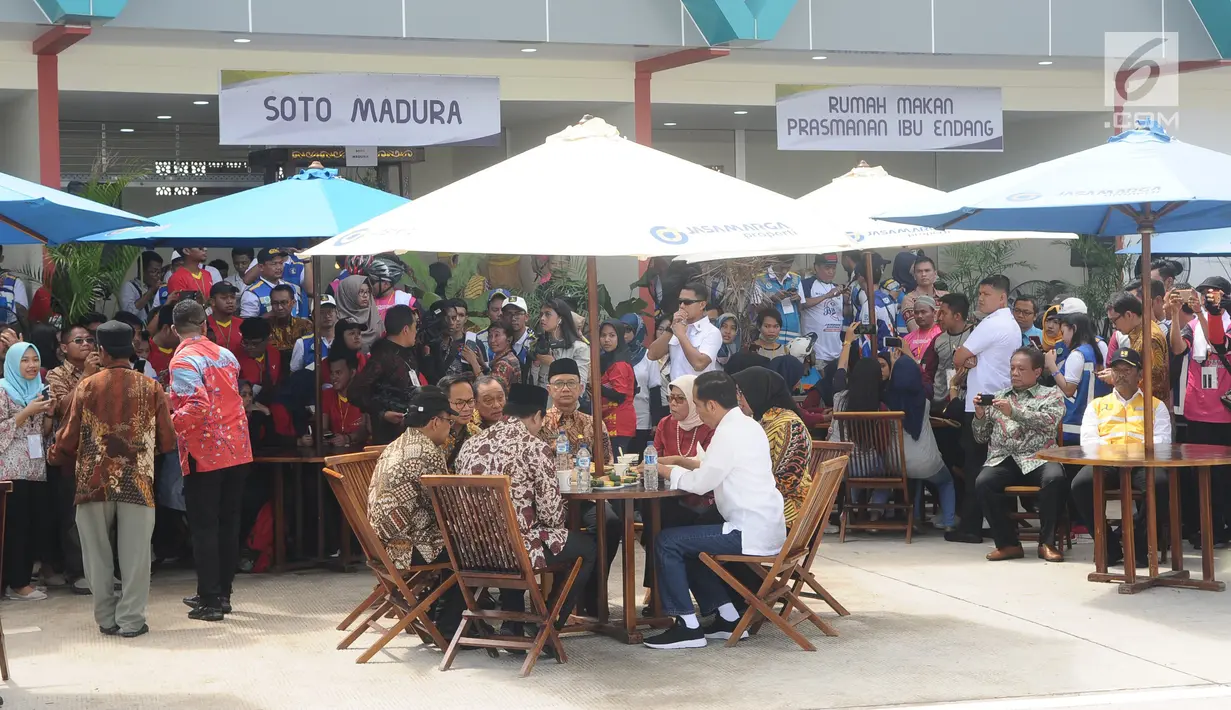 Presiden Joko Widodo (Jokowi) berbincang sambil menjajal makanan saat meninjau Rest Area 538 seusai meresmikan ruas  Tol Sragen-Ngawi, Jawa Tengah, Rabu (28/11). Jokowi duduk semeja dengan kepala serta pimpinan daerah setempat. (Liputan6.com/Angga Yuniar)