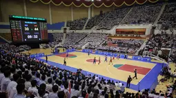 Suasana pertandingan basket antara Korea Utara (merah) dan Korea Selatan  (biru) di Stadion Indoor Ryugyong Chung Ju-Yung, Pyongyang (5/7). Tim pria Korea Utara memenangkan 82-70. (AFP Photo/Kim Won-Jin)