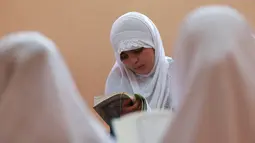 Seorang murid perempuan membaca kitab suci Alquran saat bulan suci Ramadan di sebuah sekolah di Benghazi, Libya, 5 Juli 2015. (REUTERS/Esam Al - Omran Fetori)