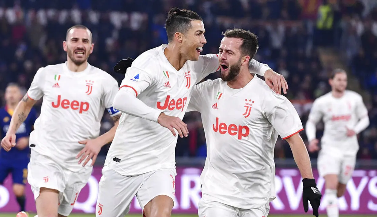 Para pemain Juventus merayakan gol yang dicetak oleh Cristiano Ronaldo ke gawang AS Roma pada laga Serie A di Stadion Olimpico, Roma, Minggu (12/1/2020). AS Roma takluk 1-2 dari Juventus. (AP/Alfredo Falcone)