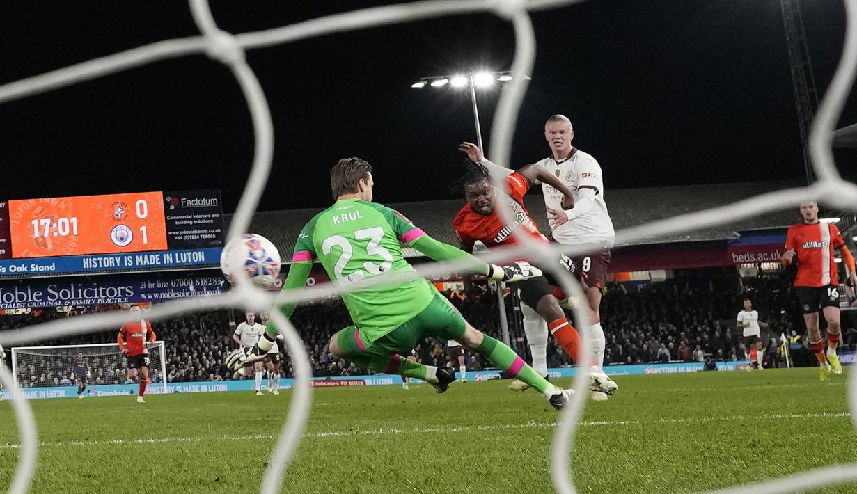 Striker Manchester City, Erling Haaland (kanan) mencetak gol kedua timnya ke gawang Luton Town yang dikawal Tim Krul pada laga putaran kelima Piala FA 2023/2024 di Kenilworth Road Stadium, Luton, Selasa (27/2/2024). (AP Photo/Alastair Grant)
