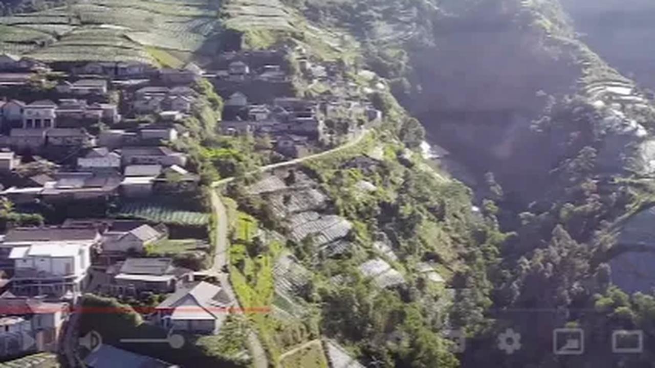Dari kejauhan, ada pula bangunan-bangunan rumah yang dididirikan di lereng bukit. <br><br>Meski bukan lahan datar, namun warga di lokasi tetap beraktivitas seperti biasa.