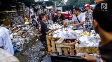 Sejumlah pedagang menyelamatkan barang dagangannya dari lokasi Pasar Induk Kramat Jati Blok C1, Jakarta Timur, yang terbakar, Senin (12/6). Sebanyak 19 unit mobil pemadam kebakaran diterjunkan untuk memadamkan api. (Liputan6.com/Faizal Fanani)