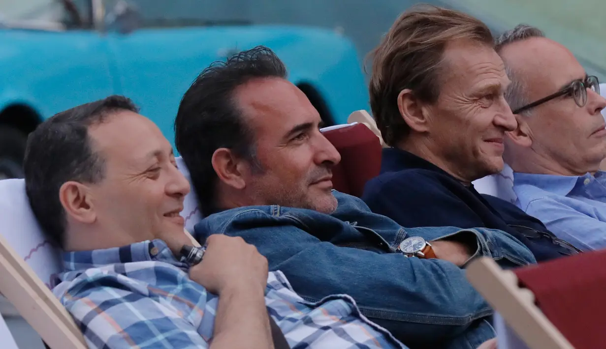Aktor Prancis Jean Dujardin menonton film gratis di ruang terbuka di jalan Champs Elysees, Paris (7/7/2019). Ratusan penonton menghadiri pemutaran film di jalan paling indah di dunia tersebut. (AP Photo/Michel Euler)