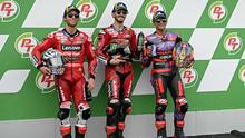 Pebalap Ducati Lenovo Team Francesco Bagnaia (tengah), Enea Bastianini (kiri) dan Jorge Martin berpose usai sesi kualifikasi MotoGP Thailand di Sirkuit Internasional Buriram, Sabtu 26 Oktober 2024. (Lillian SUWANRUMPHA/AFP)