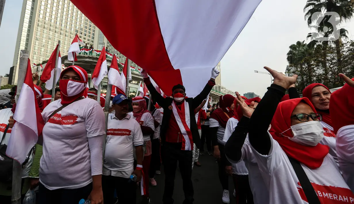 Peserta membentangkan Bendera Merah Putih di kawasan Thamrin, Jakarta, Minggu (28/8/2022). Sebanyak 50.000 orang membentangkan bendera merah putih sepanjang 1.700 meter dari kawasan Monas hingga Bundaran Hotel Indonesia dalam rangka memperingati HUT ke-77 Kemerdekaan Republik Indonesia bertemakan 'Pulih Lebih Cepat, Bangkit Lebih Kuat. (Liputan6.com/Johan Tallo)