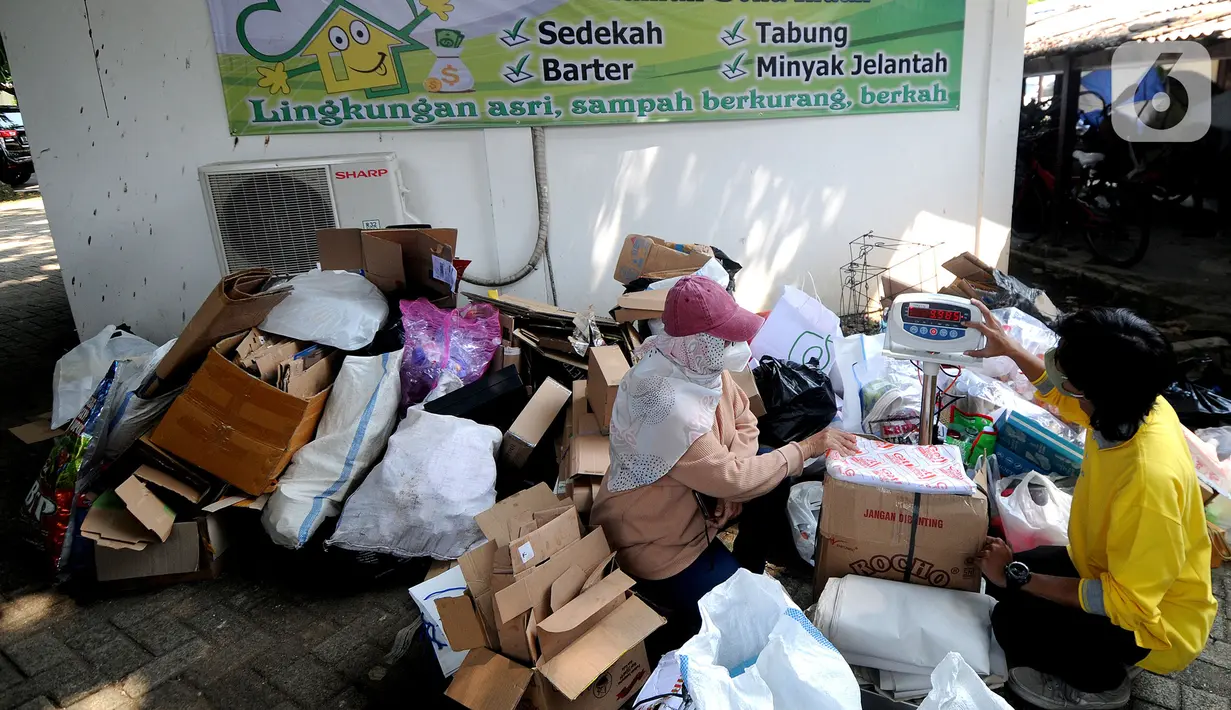 Warga mengumpulkan sampah yang akan dikonversi ke dalam buku tabungan pada salah satu perumahan elite di kawasan Lebak Bulus, Jakarta Selatan, Selasa (21/9/2021). Kegiatan ini digelar berkat kerja sama dengan Bank Sampah DKI. (merdeka.com/Arie Basuki)