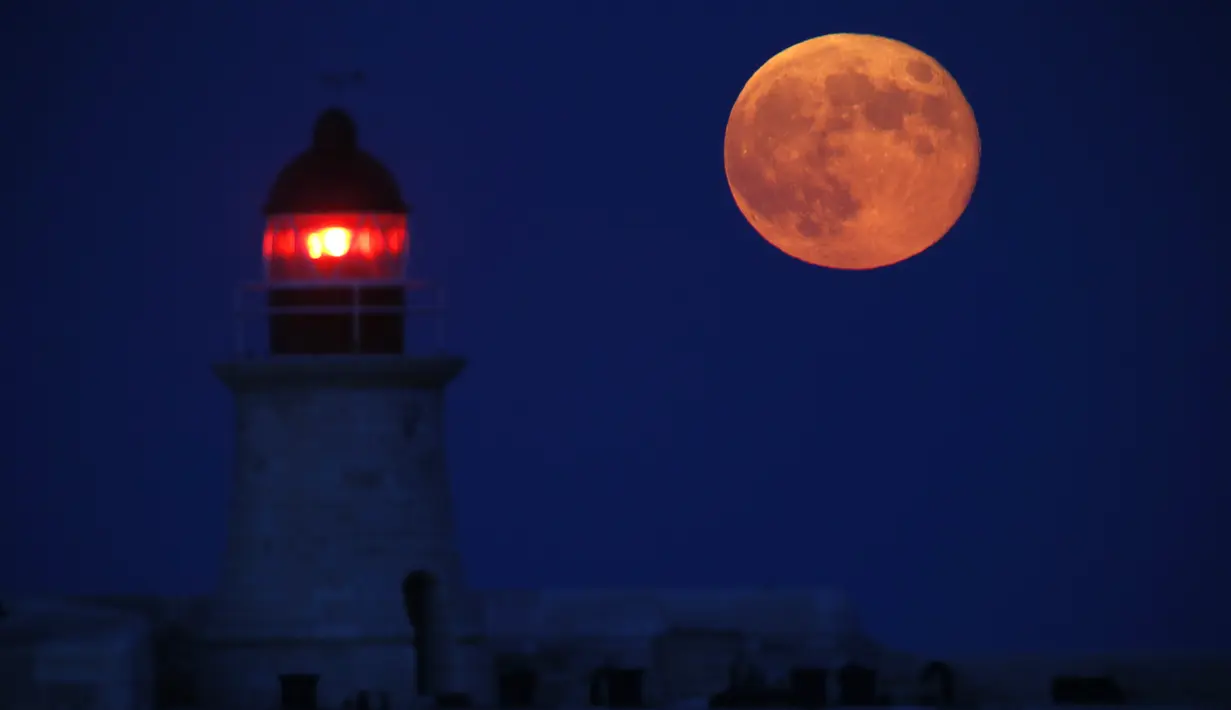 Supermoon terbit di belakang mercusuar di Valletta Grand Harbour, Malta, Selasa (9/9/14). (REUTERS/Darrin Zammit Lupi) 