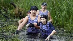 Sejumlah peserta bejalan dalam kubangan lumpur saat mengikuti kompetisi lari ekstrim di Zhodino, Minsk timur, Belarus, 26 September 2015. (REUTERS/Vasily Fedosenko)