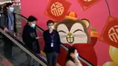 Orang-orang memakai masker saat menaiki eskalator di Bandara Internasional Hong Kong di Hong Kong, Selasa (21/1/2020). Masker terjual habis dan pemeriksaan suhu di bandara dan stasiun kereta api menjadi norma baru di China menyusul merebaknya wabah virus corona.  (AP/Ng Han Guan)