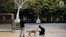 Warga membawa anjingnya saat beraktivitas di lapangan Taman Menteng, Jakarta, Kamis (1/6). (Liputan6.com/Immanuel Antonius)