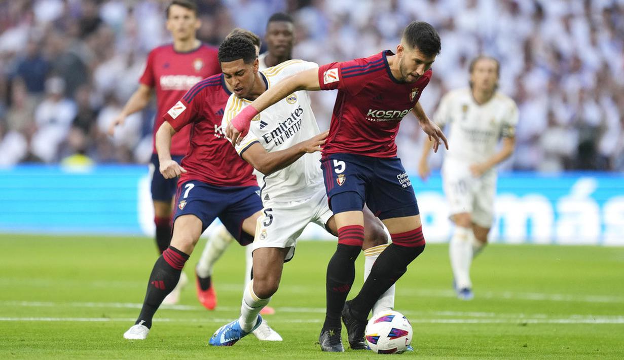 Pemain Real Madrid, Jude Bellingham, berusaha merebut bola dengan pemain Osasuna, David Garcia, pada laga pekan ke-9 La Liga 2023/2024 di Stadion Santiago Bernabeu, Sabtu, (7/10/2023). (AP Photo/Jose Breton)