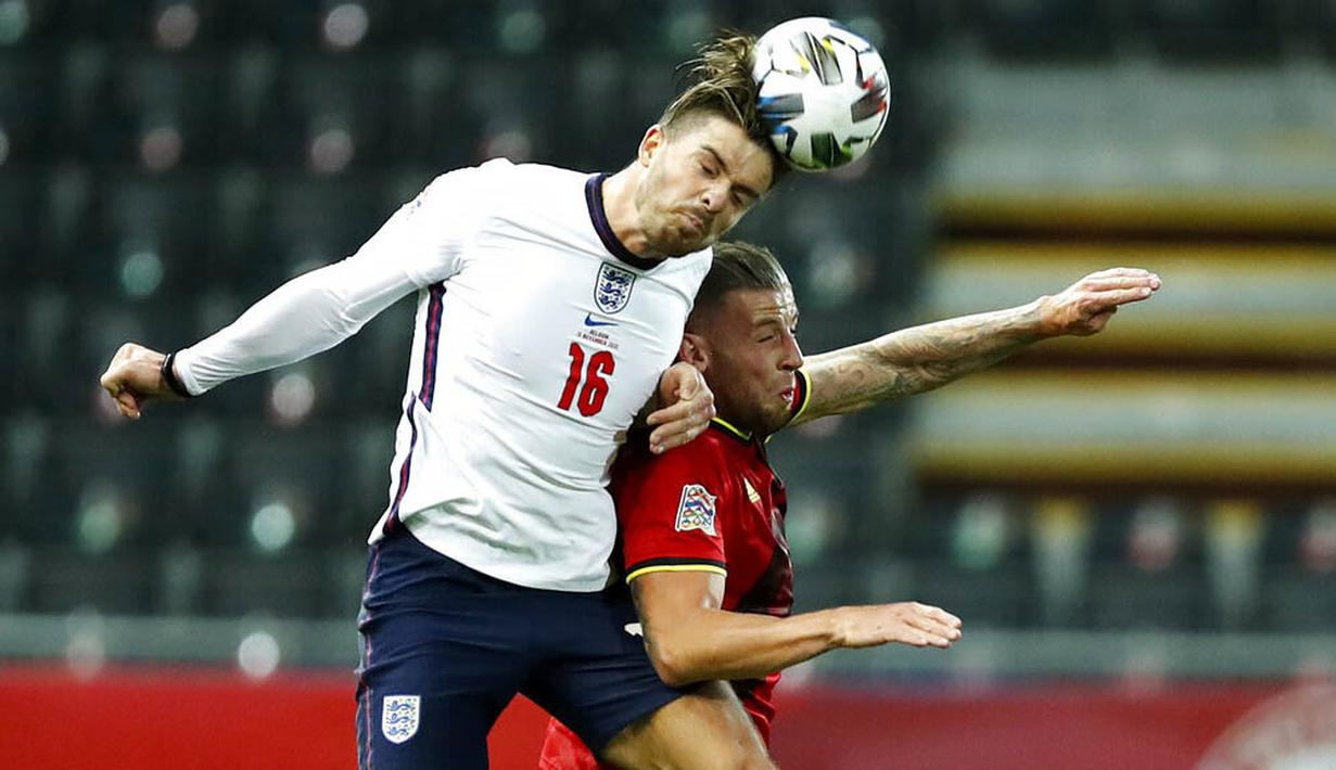 Pemain Inggris, Jack Grealish, duel udara dengan pemain  Belgia, Toby Alderweireld, pada laga UEFA Nations League di Stadion King Power, Senin (16/11/2020). Belgia menang dengan skor 2-0. (AP/Francisco Seco)