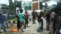 seorang mahasiswa demonstrasi di Kejati Sulawesi Tenggara, kena hantaman ember oleh petugas saat melakukan aksi protes.(Liputan6.com/Ahmad Akbar Fua)
