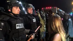 Pengunjuk rasa meluapkan kemarahannya kepada petugas kepolisian yang berjaga di lokasi unjuk rasa di Charlotte, North Carolina, AS, Selasa (20/9). Polisi akhirnya mengeluarkan gas air mata untuk membubarkan massa. (REUTERS/Adam Rhew)
