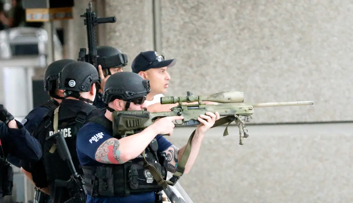 Petugas mengarahkan senjata saat memburu pelaku penembakan di Bandara Fort Lauderdale, Florida, AS (6/1). Polisi telah menangkap pelaku tunggal penembakan yang menewaskan 5 orang tersebut. (AP Photo/Wilfredo Lee)