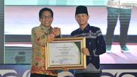 Menteri Desa, Pembangunan Daerah Tertinggal dan Transmigrasi Republik Indonesia, Dr. Drs. Abdul Halim Iskandar, M.Pd., menyerahkan penghargaan kepada Bupati Trenggalek, Mochamad Nur Arifin di Graha Sabha Pramana, Universitas Gadjah Mada, Yogyakarta.