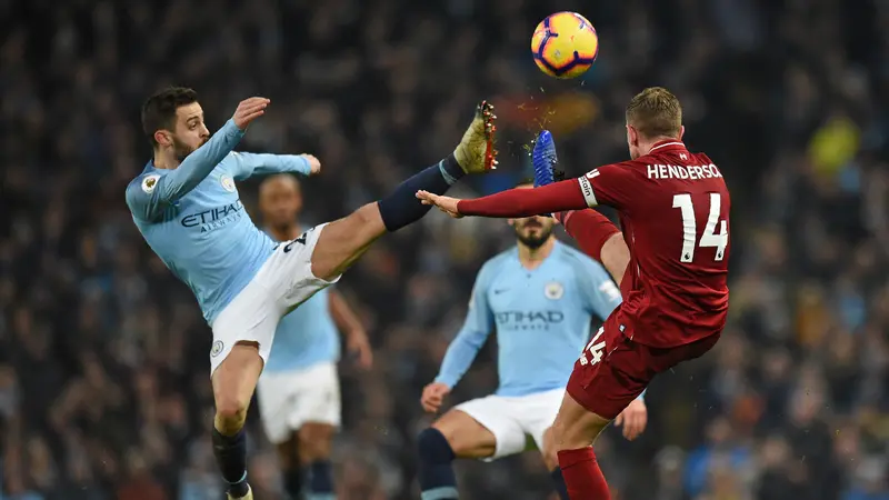 Gelandang Manchester City, Benardo Silva, berebut bola dengan gelandang Liverpool, Jordan Henderson, pada laga Premier League di Stadion Etihad, Manchester, Kamis (4/1). City menang 2-1 atas Liverpool. (AFP/Oli Scarff)