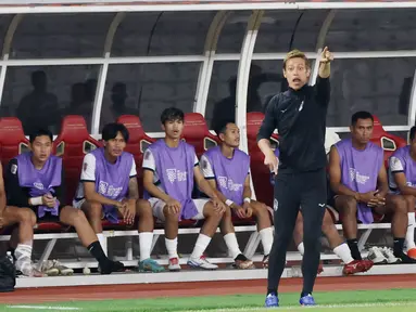 Manajer Timnas Kamboja, Keisuke Honda, tampak sibuk saat Kamboja melawan Timnas Indonesia pada laga Grup A Piala AFF 2022. (Bola.com/M iqbal Ichsan)